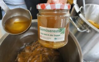 Abgefüllte Gemüsebrühe im Einmachglas mit Aufschrift "Gemüsereste - das Salz in der Suppe"