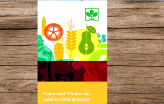 Dekoratives Foto zur Informationsbroschüre "Essen und Trinken bei Lebensmittelallergien". Abgebildet auf einem Holzhintergrund.