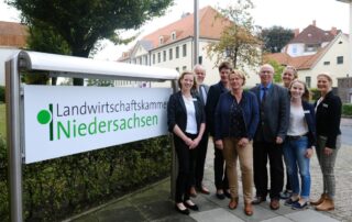 Gruppenfoto vor dem Außenschild der Landwirtschaftskammer Niedersachsen von Mitarbeitern des Zentrums für Ernährung und Hauswirtschaft (ZEHN)