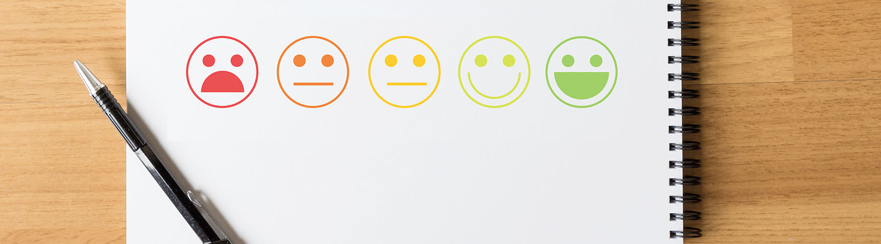 Ausschnitt eines Notizblockes mit Smileys unterschiedlicher Farbe und Stimmungslage