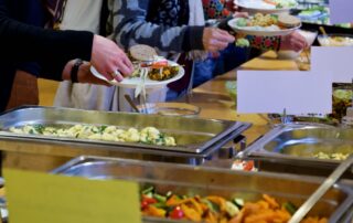 Veranstaltungsteilnehmende essen am Büffet